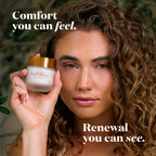 A woman with curly brown hair holds up a jar of Moisturizer against a soft, blurred green background. White text overlays read 'Comfort you can feel.