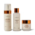 Three skincare products from Young Living on a white background: a frosted bottle of Antioxidant Foaming Cleanser, a frosted bottle of Exfoliating Toner with a metallic copper cap, and a frosted jar of Anti-Aging Intensive Moisturizer with a metallic copper lid.