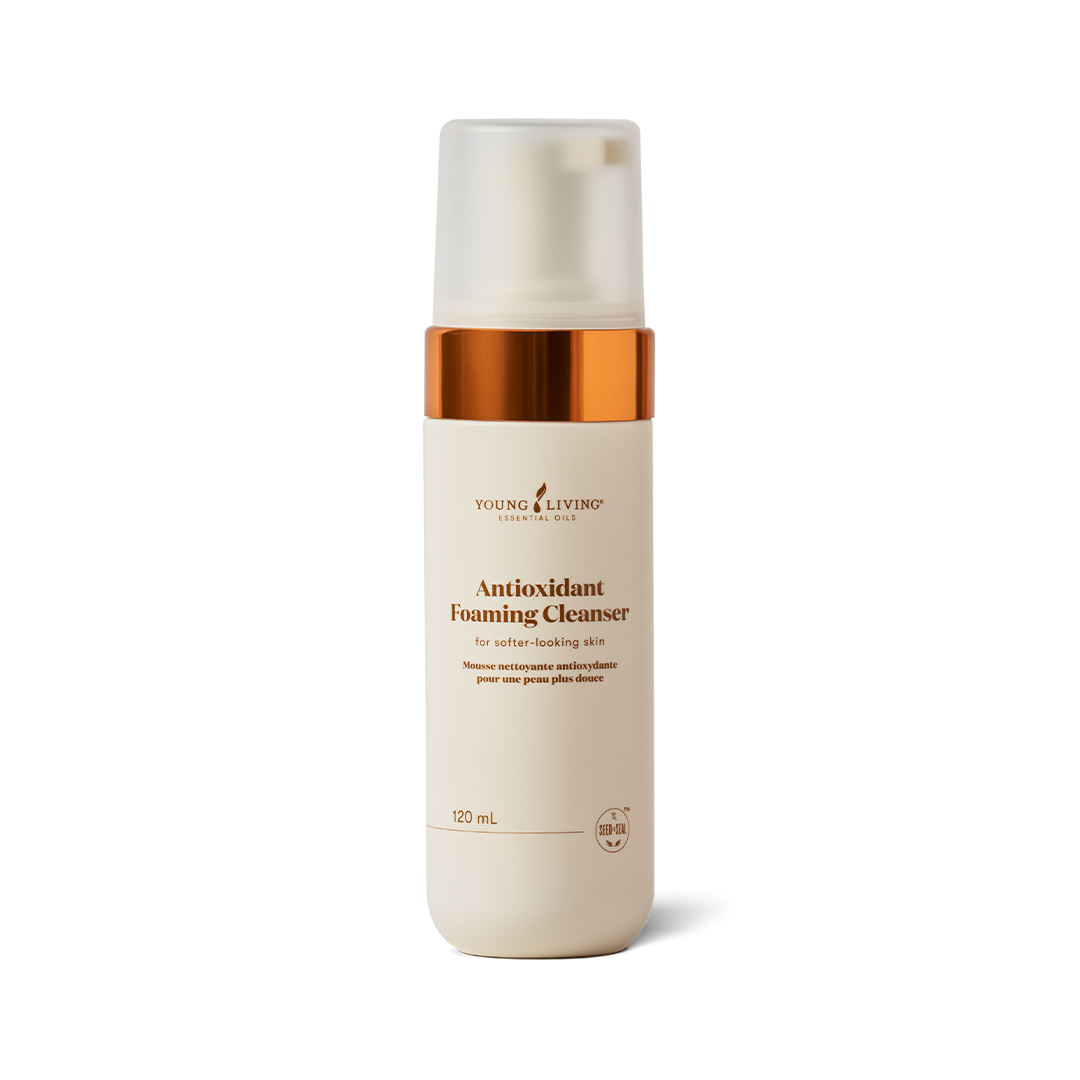 A 120 mL bottle of Young Living Antioxidant Foaming Cleanser on a clean white background. The bottle is cream-colored with a metallic copper collar and a frosted cap.