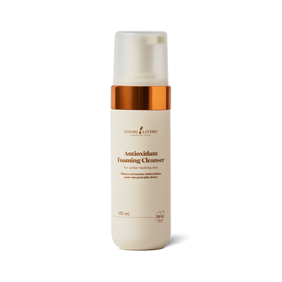 A 120 mL bottle of Young Living Antioxidant Foaming Cleanser on a clean white background. The bottle is cream-colored with a metallic copper collar and a frosted cap.