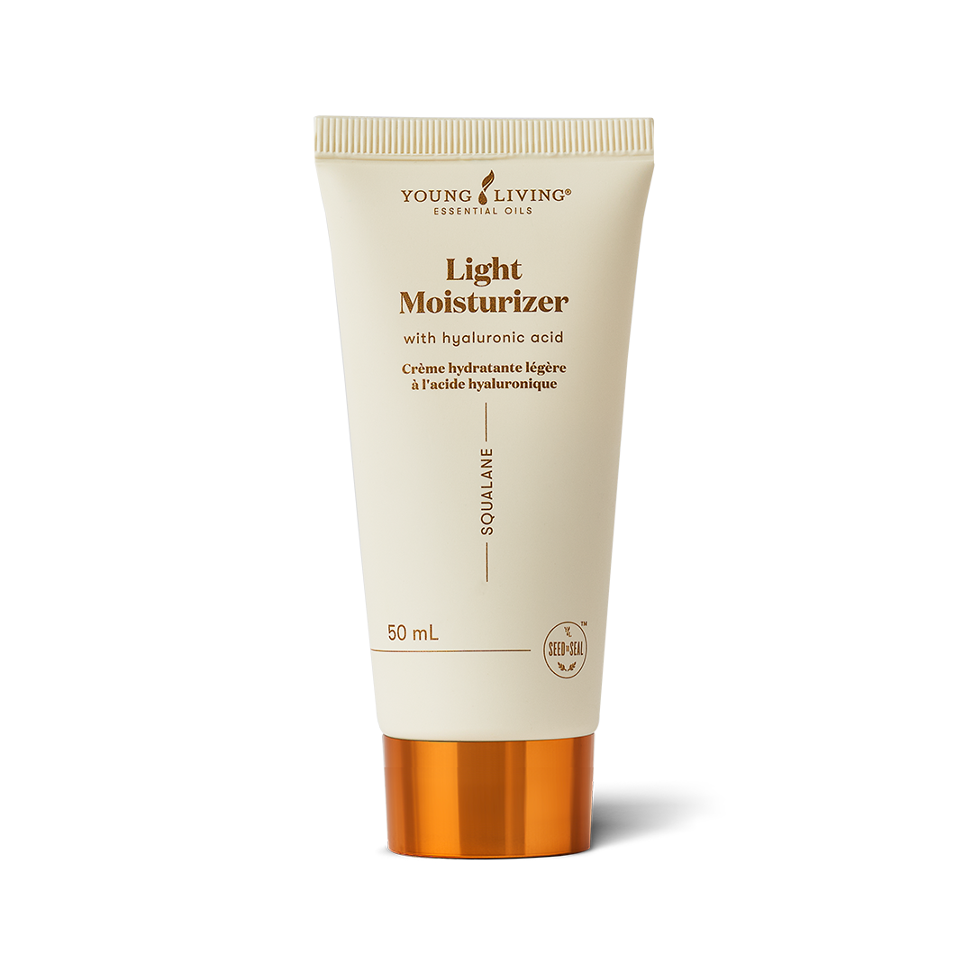 A 50 mL squeeze tube of Young Living Skin Plus Light Moisturizer with Hyaluronic Acid. The tube is a warm cream color with gold text and a metallic gold cap, set against a clean white background with a soft shadow.