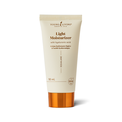 A 50 mL squeeze tube of Young Living Skin Plus Light Moisturizer with Hyaluronic Acid. The tube is a warm cream color with gold text and a metallic gold cap, set against a clean white background with a soft shadow.