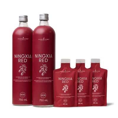 Two large glass bottles and four smaller pouches of Young Living Ningxia Red, arranged on a clean white background.