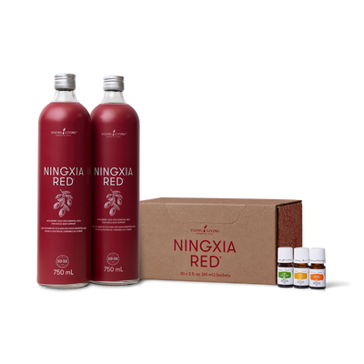 Two 750 mL bottles of Ningxia Red herbal tincture bottles with silver caps, displayed next to a brown cardboard box and three small essential oil bottles on a white background.
