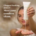 A woman holds a squeeze tube of  Cleansing Gel over her palm, with gel dripping onto her hand. 
