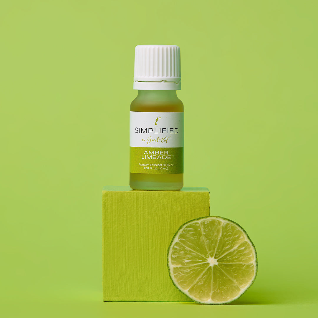 Bottle of 'Simplified' amber mead on a green block with a lime wedge on a green background