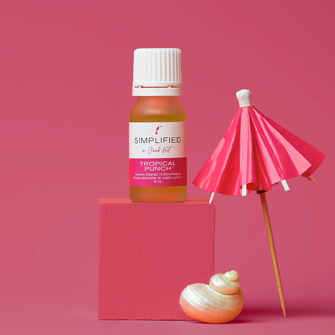 Simplified Tropical Punch perfume bottle with a pink umbrella and shell on a pink background