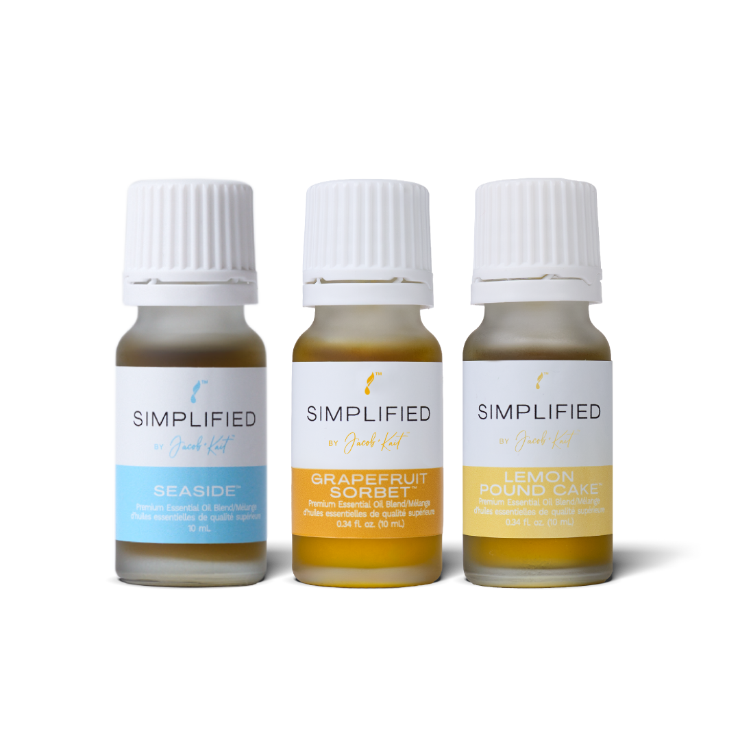 Three small glass essential oil bottles of Simplified by Jacob + Kait : Seaside, Grapefruit Sorbet, and Lemon Pound Cake.
