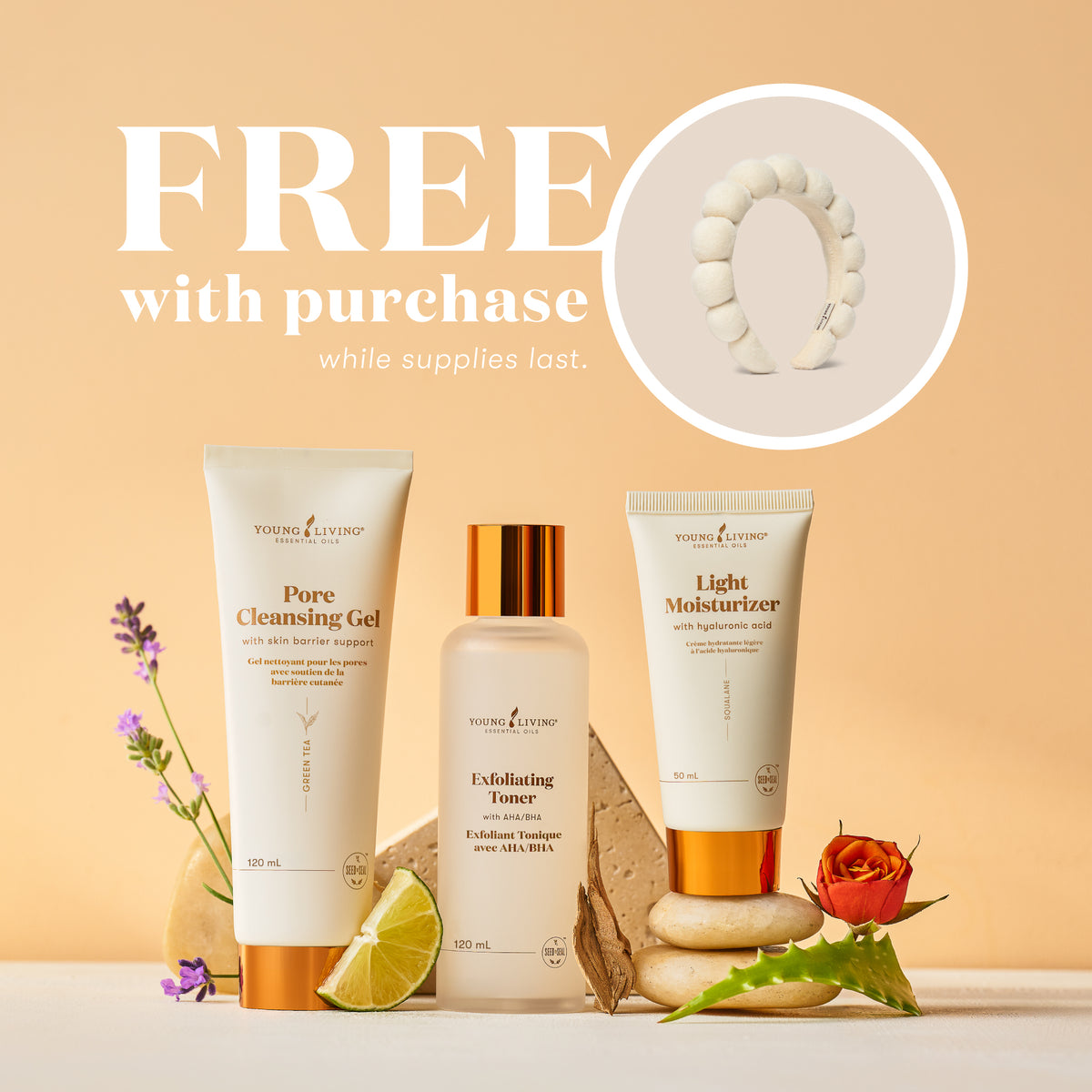Three Young Living skincare products are displayed on a beige surface against a warm beige background, with promotional text reading 'FREE with purchase while supplies last.' and a circular inset showing a white headband.