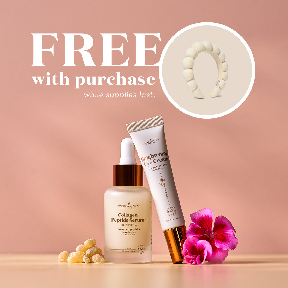 Two skincare products are arranged on a beige surface against a soft peach-pink background, with promotional text reading 'FREE with purchase while supplies last.' and a circular inset showing a white headband.